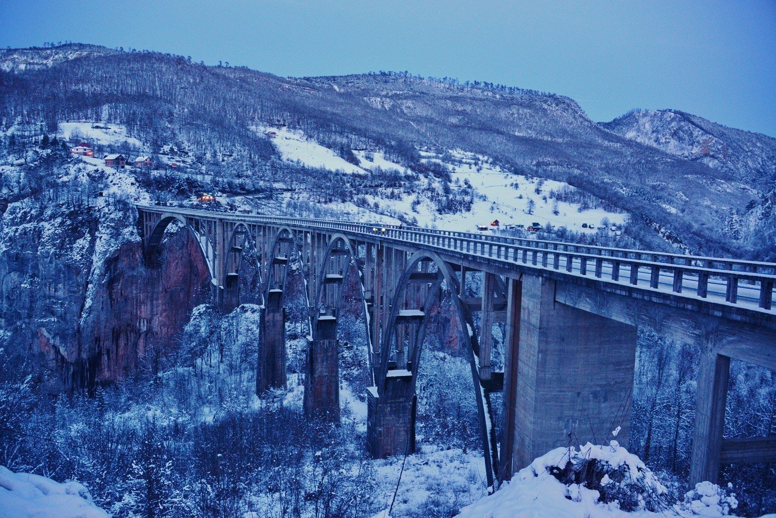 Википедия: Мост Джурджевича через реку Тара был спроектирован Mijat Trojanović и построен между 1937 и 1940 годами в королевстве Югославия. Главный инженер проекта - Исаак Руссо. 365 метровый (1,198 футов) в длину мост имеет пять арок; самый большой пролет составляет 116 метров (381 футов). Высота моста 172 метра (564 фута) над рекой Тара. На момент окончания строительства он был самым большим автомобильным бетонным арочным мостом в Европе.